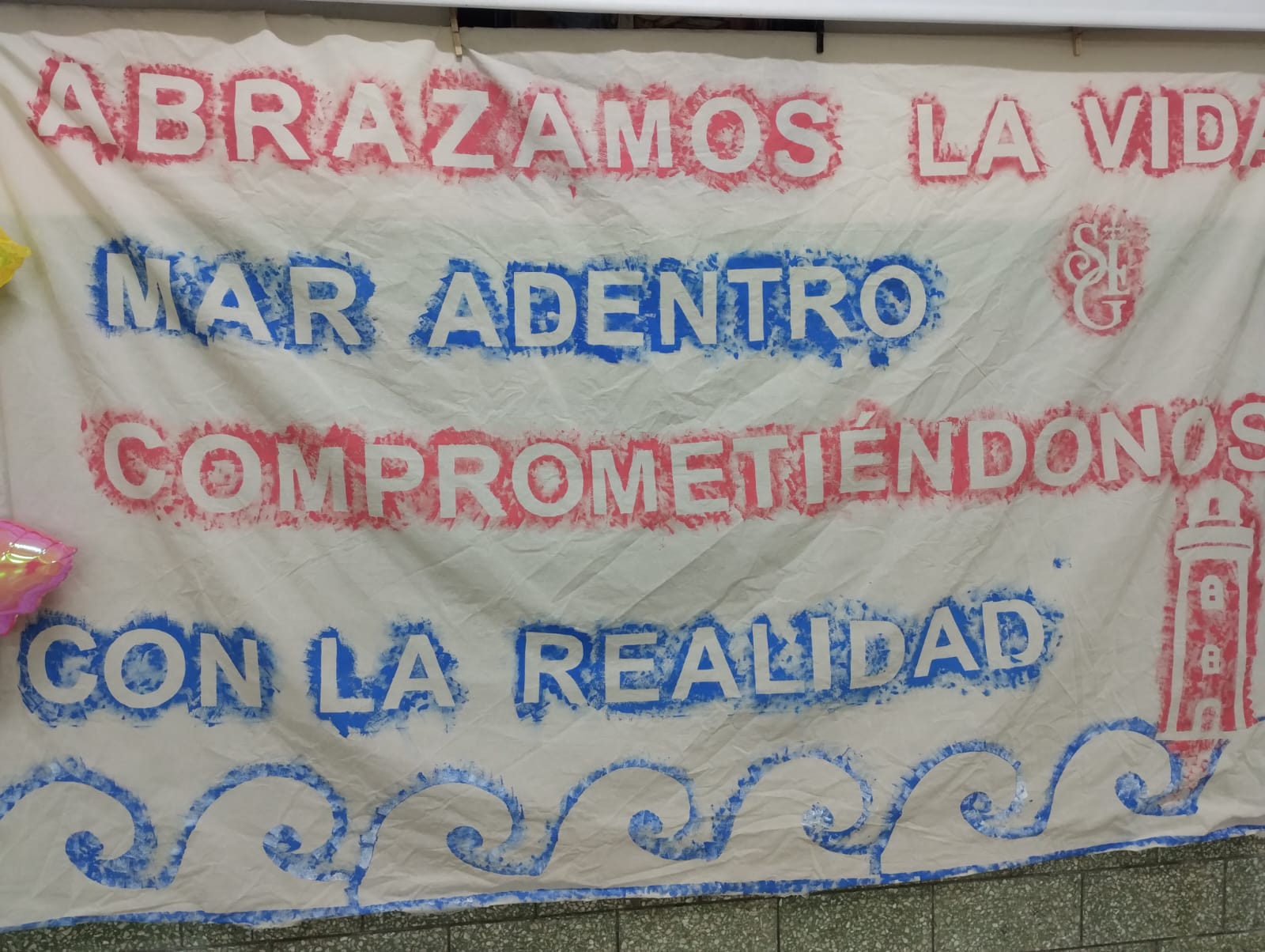 Bandera terminada con el lema Abrazamos la vida, mar adentro, comprometiéndonos con la realidad